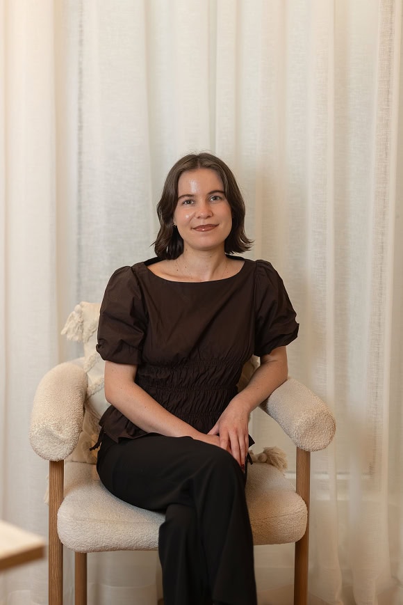 Molly Ohlback, naturopath and corneotherapist, seated in a cream armchair